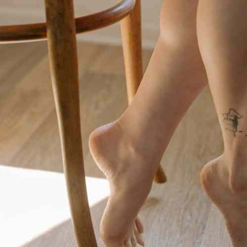 person with black tattoo on leg
